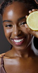 Face, skincare and happy black woman with lemon for beauty, makeup cosmetics and healthy diet. Portrait, smile and model with citrus fruit for natural vitamin c isolated on dark studio background