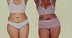 Holding hands, plus size body or happy women in underwear in studio isolated on green background. Positivity, inclusion or friends in lingerie, beauty or support diversity of different girls together