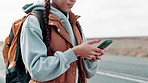 Woman, smartphone and road trip for travel with backpack to town, text and holiday adventure journey. Tourist, explore and happy on sidewalk, social media post and girl typing for winter vacation 