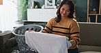 Woman, living room and laundry with smell or happiness for cleaning, hospitality service with care. Female cleaner, apartment or basket for fresh towel or clothes, maintenance or housework with smile