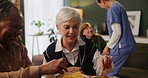 Nursing home, snack and senior women with lunch, happiness and bonding together with reunion. Chatting, treat and food with fun, conversation and communication with elderly people, nurse and eating