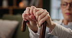 Hands, walking stick and senior woman for balance with recovery from stroke, osteoporosis or injury. Cane, retirement and person with disability on sofa for rehabilitation in lounge at nursing home