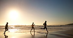 Ocean, sunset and silhouette of friends with running on sand for fun, trust and adventure together. Nature, waves and people with energy at beach for outdoor travel, vacation and holiday in Cancun