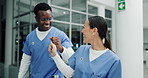 Doctors, fist bump and together for success in team at hospital, happy and cheers with solidarity. People, nurse or surgeon with celebration, paperwork and synergy with diversity in lobby at clinic