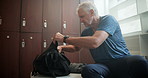 Man, locker room and sitting with backpack for workout, preparation for exercise in gym. Mature, male person and fitness with hands and bag for planning, smartwatch for health goals or sport training