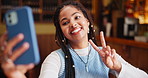 Black woman, cafe and selfie with peace sign for memory, photography or picture at indoor restaurant. Young African, female person or student with smile or emoji for moment or capture at coffee shop