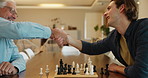 Chess, senior father and son with fun, handshake and bonding together with happiness, winning and chilling. Chatting, board game and relax with family, elderly man and people with hobby and victory