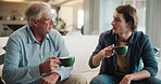 Senior father, son and coffee on sofa for discussion, advice and happy bonding together in home. Conversation, dad and adult child chat on couch with drink, care and relax on weekend in living room.