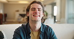 Happy, face and man in home with laughing, relax and morning on a living room sofa. Portrait, funny and student on break in lounge with confidence on a couch with smile and joke on university holiday