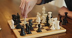 Chessboard, game and hands with checkmate, home or contest with strategy for problem solving with win. Board, toys and goals for people in challenge for king, knight and queen pieces with competition