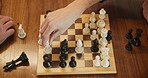 Chessboard, game and hands for checkmate, winner or contest with strategy for problem solving in home. Board, toys and goals for people in challenge for king, knight and queen pieces with competition