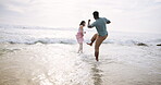 Water splash, couple and playing by beach with care, fun and playful together with happiness on vacation in Australia. Man, woman and ocean waves on holiday for weekend trip, anniversary and game.