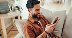 Phone, text and happy man in a home with social media, internet and website scroll on a lounge sofa. Video, meme and smile relax at a home with app, streaming and typing online for web post comment