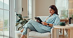 Happy, relax and woman with tablet on sofa for online chat, communication and networking. Typing, home and person smile on digital tech for social media, website and internet news in living room
