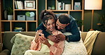 Couple, happy and sofa for hug with smartphone, smiling and love in home for relationship bonding together. Living room, woman browsing and relax communication on social media, man and affection