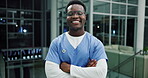 Black man, confident and face of nurse in hospital, healthcare and medical specialist at night. Male person, arms crossed and proud physician in portrait, surgeon and medicine or medicare expert