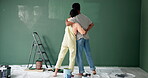 Back, couple and hug for painting on wall in new home or house for renovation with bonding. People, relationship and love with diy to enjoy, support and care for teamwork, collaboration and trust