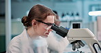 Woman, scientist and forensic with microscope for research, new discovery or examination at laboratory. Female person or biologist looking through scope for science, dna test or chemistry at lab