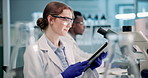 Scientist, woman and microscope or tablet in laboratory for results on medical research or experiment. Digital tech, professional or student with analysis on science development, study review or info