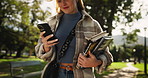 Happy woman, student and walking with phone or books in park for communicatio, social media or reading news. Female person on mobile smartphone for online browsing, learning or education in nature