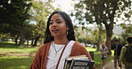 Black woman, student and walking with books in nature for learning, education or studying at outdoor park. Young African with smile or textbooks for academic journey or ambition at campus or college