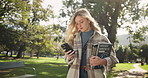 Woman, student and walking with phone or books in nature for outdoor communication, social media or reading. Female person in stroll with textbooks on mobile smartphone for online learning at park