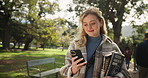 Woman, student and walking with phone in nature for outdoor communication, social media or reading. Female person in stroll with books on mobile smartphone for online learning or education at park