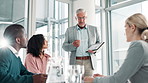 Mature businessman, tablet and coaching with team in presentation for meeting, strategy or collaboration at office. Man, CEO or mentor talking to group of employees with technology for discussion