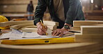 Carpenter, hands and pencil with drawing for construction, furniture or project. Closeup of person with design, wood and tools in a creative carpentry workshop for manufacturing, art or product craft