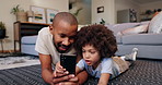 Phone, relax and father with child on floor in living room playing online game together. Bonding, happy and dad scroll on internet, mobile app or website on cellphone with boy kid on carpet at home.