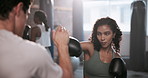 Gym, boxing and coach with girl for punching, exercise and training class. Fitness center, female client and male personal trainer for supervision, teaching and motivation for beginner boxer