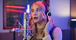 Production, artist and woman with singing in studio for entertainment, recording and song in album. Musician, microphone and neon with headphones for sound media, audio and broadcast at record label