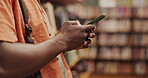 Library, shelf and hand of man with phone for university contact, information or typing email. Student, education and person with technology at academy for schedule, communication or research on book