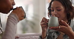 Coffee, friends and women in home with cheers for conversation, talking and chat for social visit. Living room, happy and girls on sofa with drink, caffeine or beverage for bonding, relax or wellness