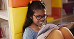 Reading book, girl and kid with smile, relax and hobby with fantasy, storytelling and happiness in library. Childhood development, literature and student with glasses, comfort and learning with break