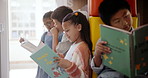 Assessment, children and reading in classroom together for educational development, group learning and growth. Students, book and studying in school for support, knowledge and storytelling or bonding