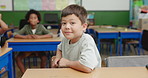 Boy, face and happy student in classroom, kindergarden portrait and desk for education for academy lesson with kids. School, knowledge and pride or ready for learning in morning, smiling and growth