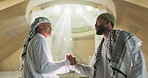 Muslim, men and handshake with hug in mosque for greeting, respect and support in islamic community. Friends, people and shaking hands with embrace in place of worship for prayer, peace and talking