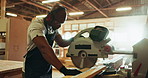 Black man, circular saw and timber for construction, building or project in store for material, wood or supply. Male people, contractor and manufacture for factory, workshop as carpenter in warehouse
