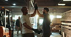 Men, carpenter and workshop with teamwork high five, support and celebration for collaboration with employees. Wood work, good job and craftsman with lumber warehouse, hug and happy together