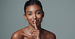 African woman, portrait and finger with hush, studio and silence for mystery announcement. Model, skincare secret and gossip with rumor, whisper and gesture for news with privacy on gray background