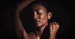 Woman, sensual and glow for skincare with beauty, natural shine and erotic confidence in dark studio. Girl, dermatology and body with skin shimmer, sexuality and sexy movement by black background