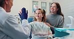 Girl, child and happy with high five for dentist for success of treatment, friendly and build trust for procedure. Pediatric, patient and hand gesture for well done, good behavior and celebration.