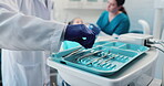 Dentist, hand and tools with people in treatment office for appointment, checkup or dental hygiene. Equipment, healthcare or medical and doctor at tray with patient for oral care examination