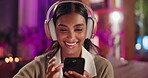 Woman, headphones and typing with social media, night and relax with technology and smile at home. Girl, listen and tapping with mobile app, fun and happiness in apartment with online music and meme