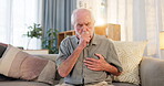 Senior man, home and cough with chest pain on sofa in living room with asthma attack. Pensioner, heartburn or heart ache on couch with lung infection, bacteria and chronic medical condition and sick