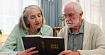 Senior couple, people and home with bible for religious or spiritual practice, knowledge and study. Relationship, Christian and bonding with reading scripture for healing, hope and faith with trust