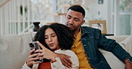 Black couple, hug and phone for social media in home, speaking and planning vacation online. People, embrace and reading ebook on weekend or relax on couch, support and app for streaming online