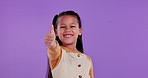 Happy girl, child and thumbs up with emoji in studio for feedback, review or good news on a purple background. Portrait of female person or little kid with smile, like or yes sign on mockup space