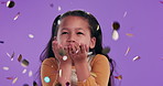 Confetti, happy and face of child in studio with sparkles for celebration, birthday party and festival. Magic, youth and portrait of young girl with decoration, glitter and fun on purple background